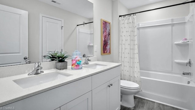 full bath with double vanity, shower / bath combination with curtain, toilet, and a sink