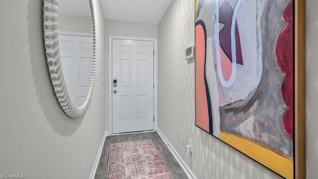 doorway with baseboards and wood finished floors