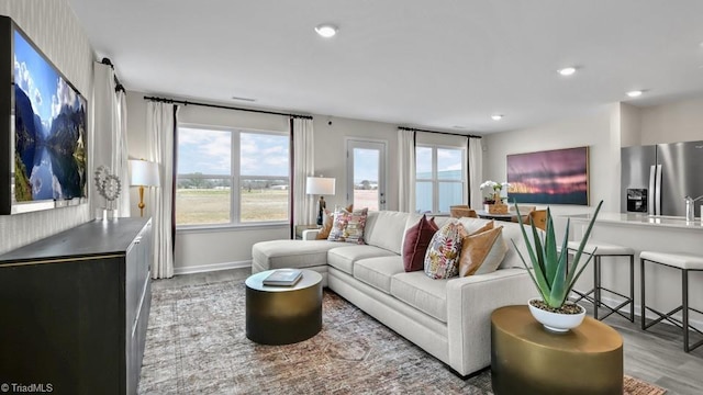 living area with recessed lighting, baseboards, and wood finished floors