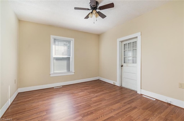 spare room with ceiling fan, hardwood / wood-style flooring, and a textured ceiling