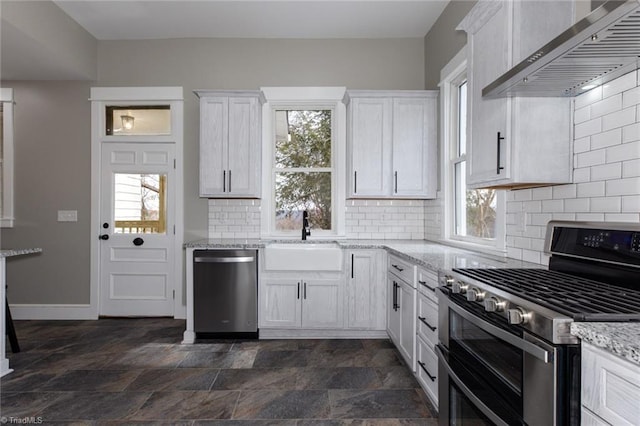 kitchen featuring wall chimney exhaust hood, white cabinetry, and stainless steel appliances