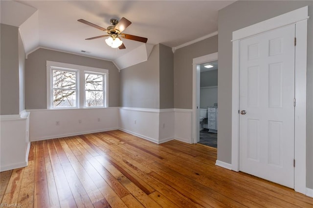 empty room featuring ceiling fan, lofted ceiling, crown molding, and light hardwood / wood-style floors