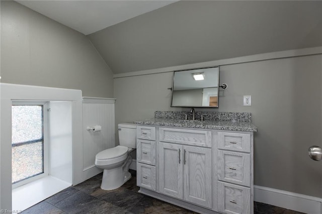 bathroom featuring lofted ceiling, toilet, and vanity