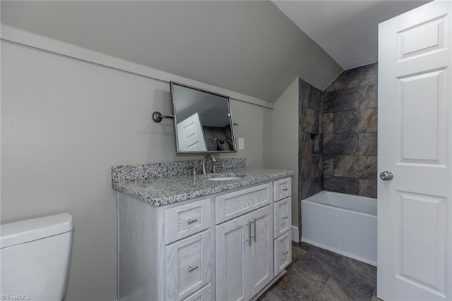 full bathroom featuring vanity, lofted ceiling, tiled shower / bath, and toilet