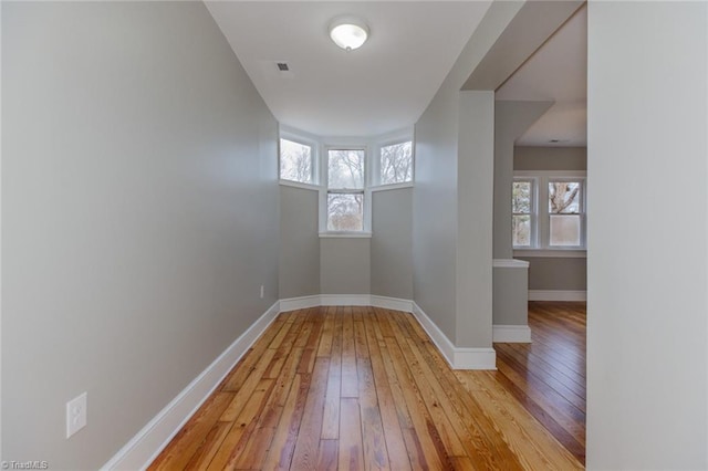 empty room featuring a healthy amount of sunlight and light hardwood / wood-style flooring