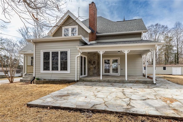 rear view of house featuring an outdoor structure and covered porch