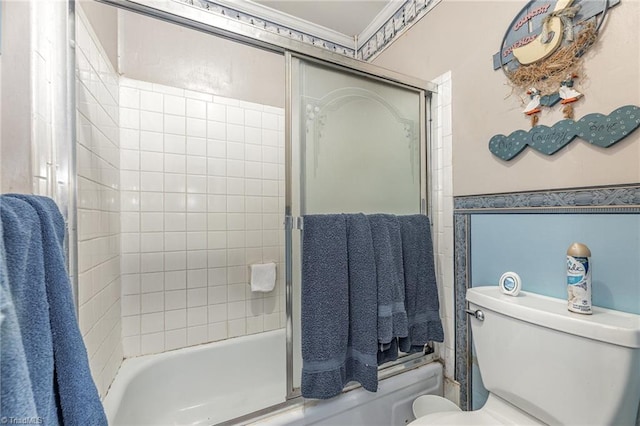 bathroom with toilet, shower / bath combination with glass door, and crown molding