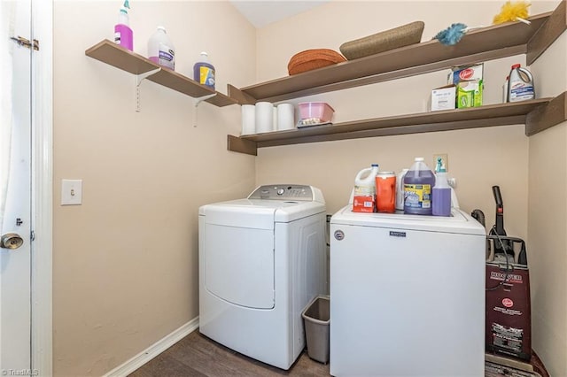 washroom with washing machine and clothes dryer and hardwood / wood-style flooring