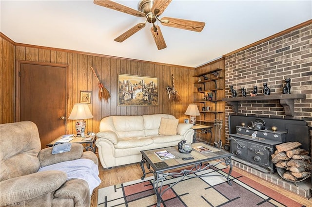 living room with built in shelves, wooden walls, light hardwood / wood-style floors, and a wood stove