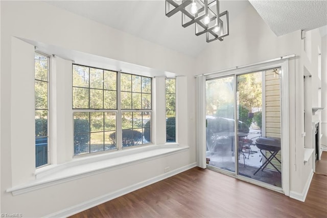 unfurnished sunroom featuring a notable chandelier and vaulted ceiling