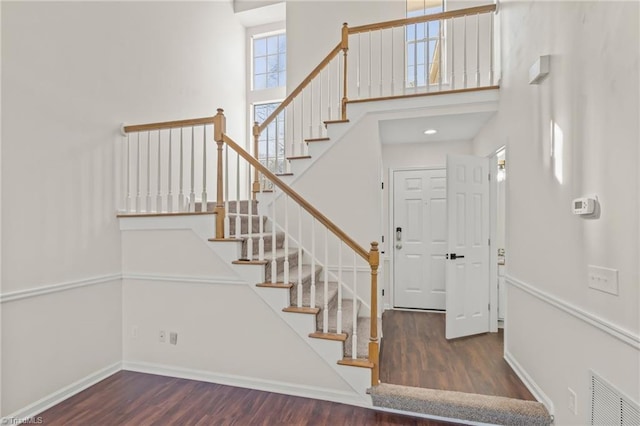 entryway featuring a towering ceiling and dark hardwood / wood-style floors