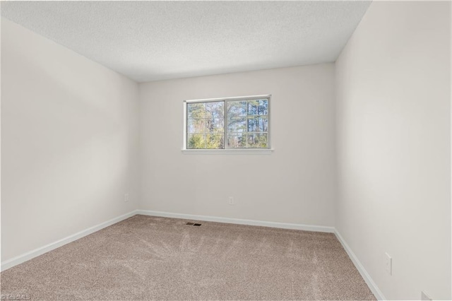 carpeted empty room with a textured ceiling