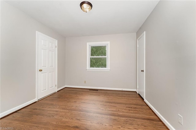 1705 Boyden St, Greensboro, NC 27403 - unfurnished bedroom featuring wood finished floors and baseboards