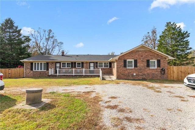 ranch-style house with brick siding, fence, a front yard, and a deck