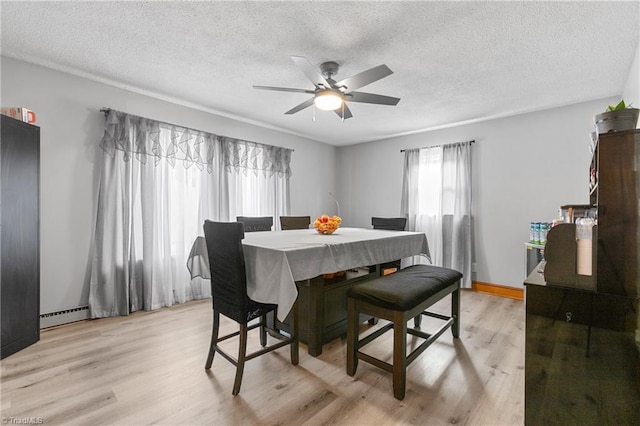 dining room with light wood-type flooring, a ceiling fan, a textured ceiling, and baseboard heating
