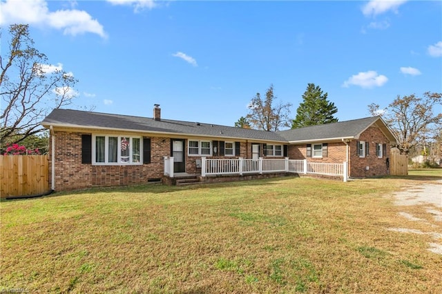 view of front facade featuring brick siding, a chimney, and a front yard