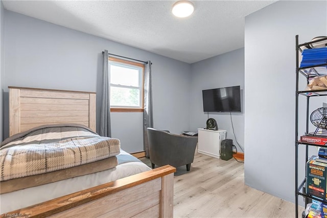 bedroom featuring a textured ceiling and wood finished floors