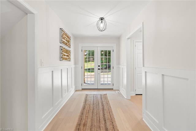 135 Boxwood Cir, Advance, NC 27006 - doorway to outside with a decorative wall, french doors, a wainscoted wall, and light wood-style floors