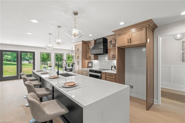 135 Boxwood Cir, Advance, NC 27006 - kitchen featuring custom exhaust hood, a sink, stainless steel electric range, a chandelier, and a breakfast bar area