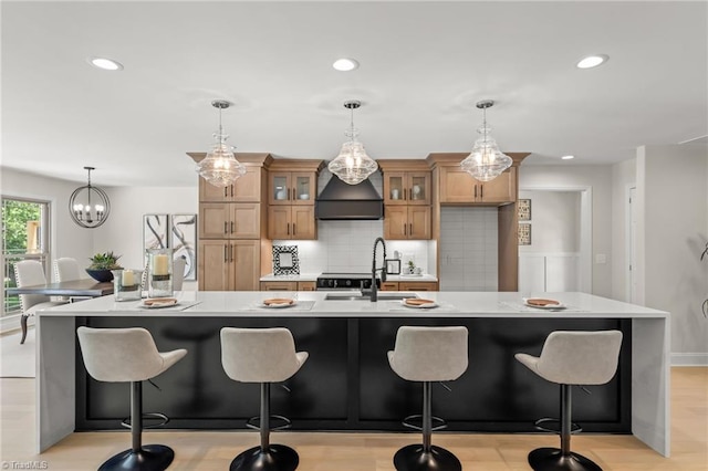 135 Boxwood Cir, Advance, NC 27006 - kitchen with custom exhaust hood, light countertops, decorative backsplash, brown cabinets, and glass insert cabinets