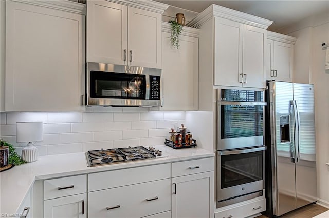 5927 Clouds Harbor Trl, Clemmons, NC 27012 - kitchen featuring appliances with stainless steel finishes, white cabinetry, decorative backsplash, and light countertops