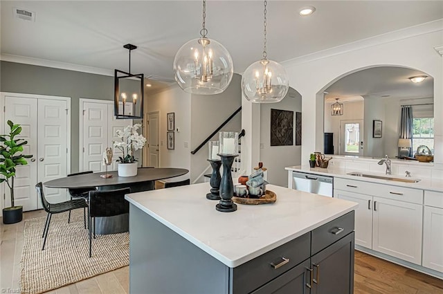 5927 Clouds Harbor Trl, Clemmons, NC 27012 - kitchen featuring arched walkways, dishwasher, a sink, a center island, and ornamental molding