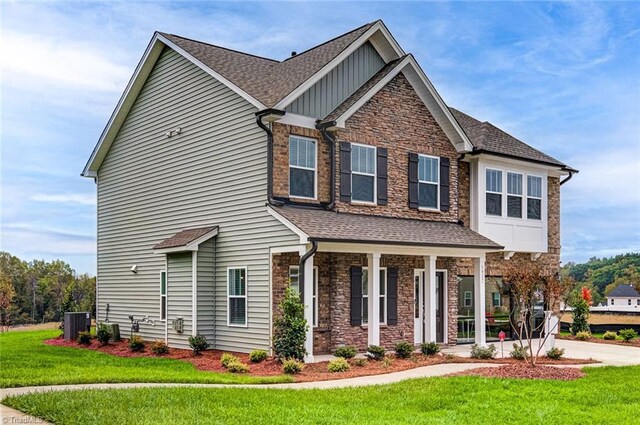 5927 Clouds Harbor Trl, Clemmons, NC 27012 - craftsman inspired home featuring stone siding, roof with shingles, a front yard, a porch, and board and batten siding