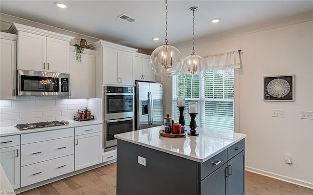 5927 Clouds Harbor Trl, Clemmons, NC 27012 - kitchen featuring stainless steel appliances, white cabinetry, decorative backsplash, light wood-type flooring, and a chandelier