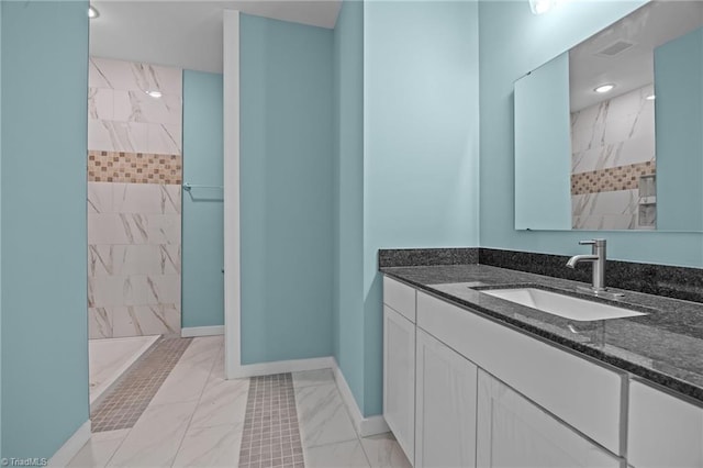 bathroom featuring a marble finish shower, marble finish floor, and baseboards