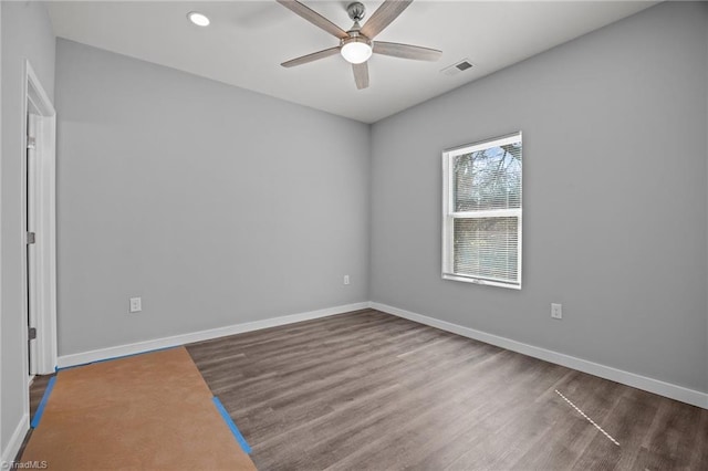 spare room with visible vents, baseboards, wood finished floors, and a ceiling fan