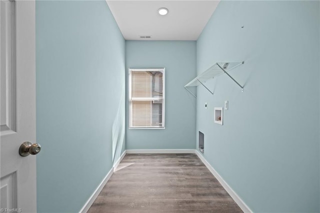 washroom with wood finished floors, visible vents, hookup for an electric dryer, baseboards, and laundry area