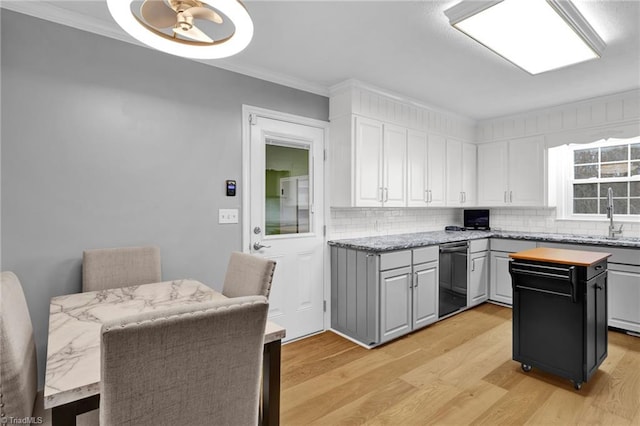 kitchen with a center island, tasteful backsplash, crown molding, white cabinets, and light wood-type flooring