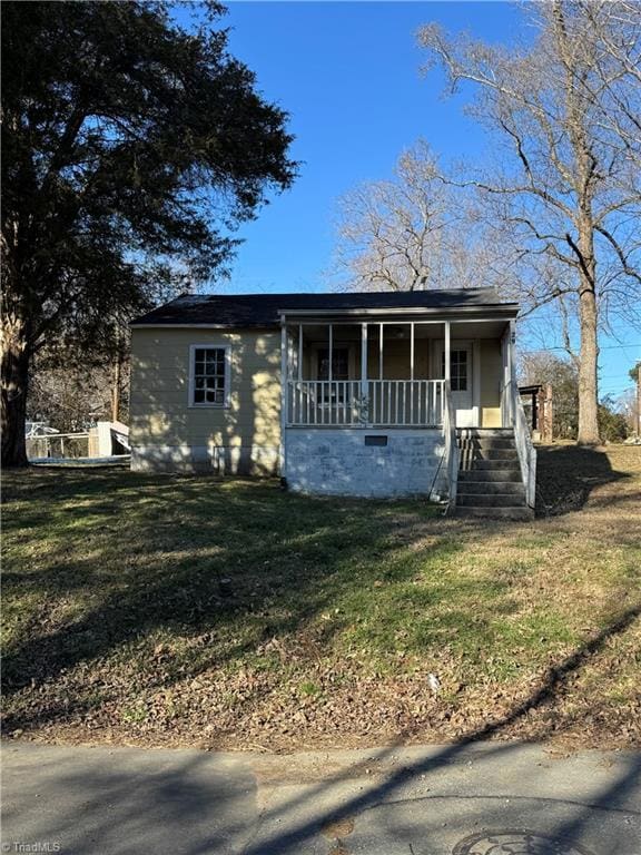 view of front of house with covered porch and a front lawn