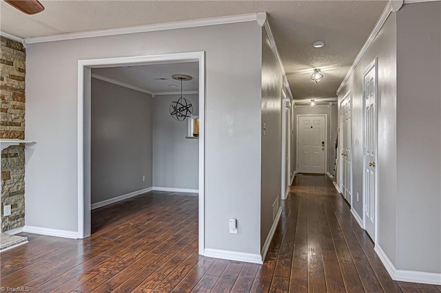 hall featuring a notable chandelier, dark hardwood / wood-style floors, ornamental molding, and a textured ceiling