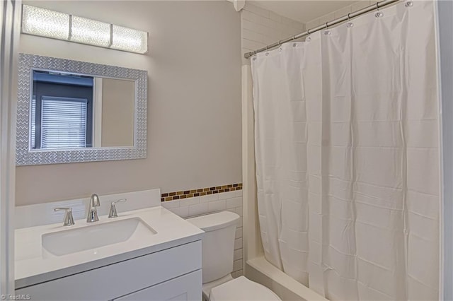 bathroom with vanity, tile walls, and toilet