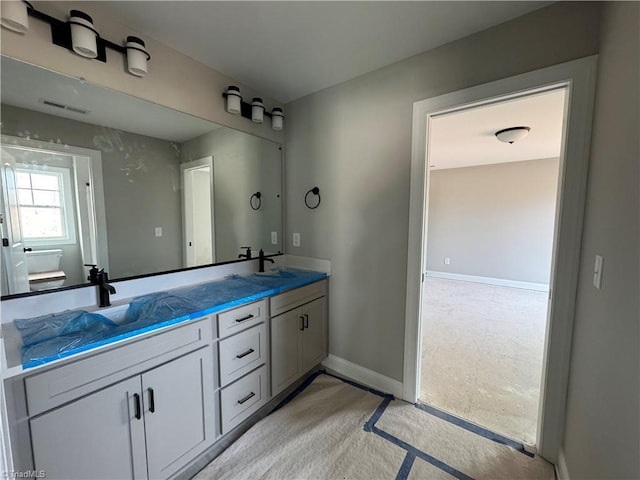 full bathroom featuring double vanity, baseboards, visible vents, and a sink