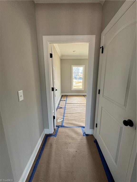 corridor featuring crown molding and baseboards