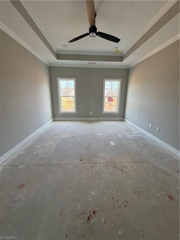 unfurnished room with a tray ceiling, a wealth of natural light, and baseboards