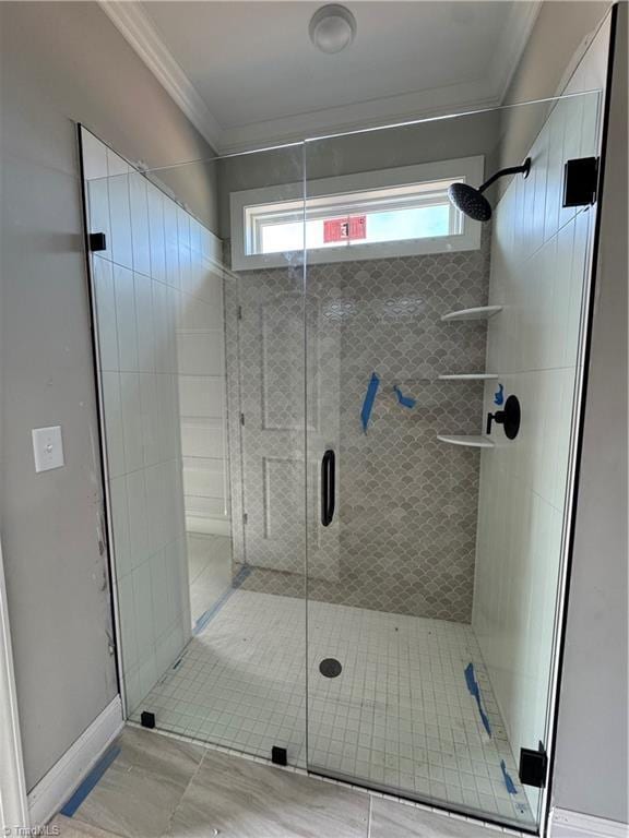 full bath with ornamental molding, a stall shower, and baseboards