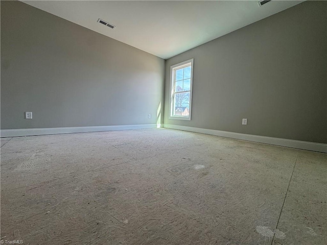 unfurnished room featuring vaulted ceiling, visible vents, and baseboards