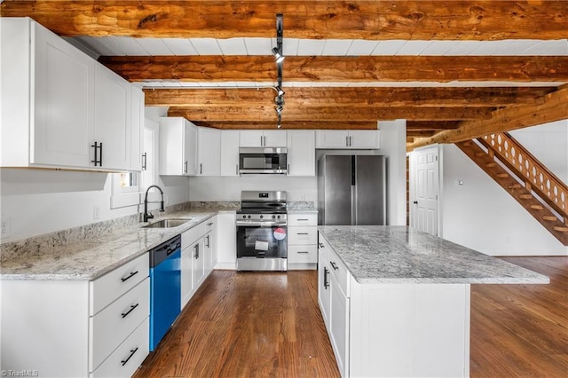 kitchen featuring appliances with stainless steel finishes, dark wood-style flooring, a sink, and beamed ceiling