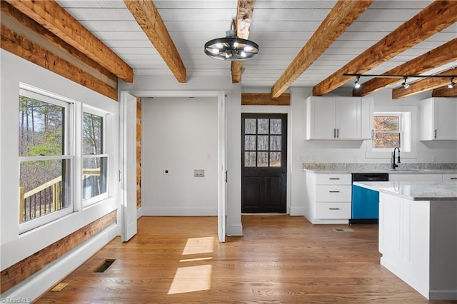 kitchen featuring beam ceiling, light wood-style floors, white cabinets, dishwasher, and baseboards