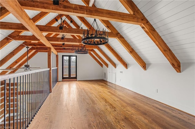 additional living space with lofted ceiling with beams, light wood-style flooring, visible vents, and a chandelier