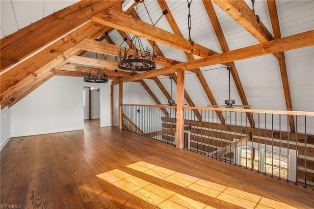 bonus room featuring vaulted ceiling with beams, baseboards, and wood finished floors