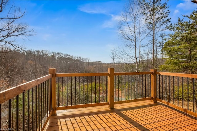 wooden terrace featuring a forest view