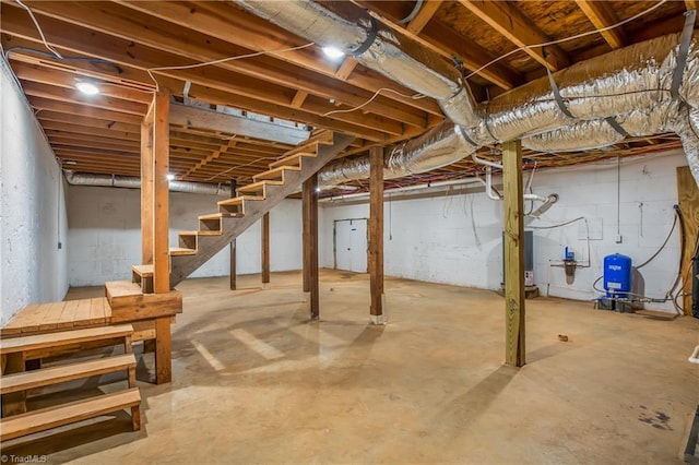 unfinished below grade area featuring stairs and gas water heater