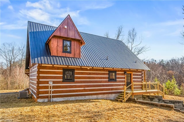 exterior space featuring metal roof, central AC unit, and log siding