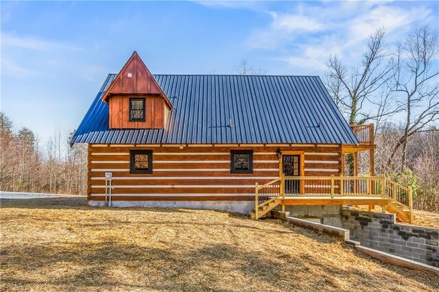 view of front of property featuring metal roof and log siding