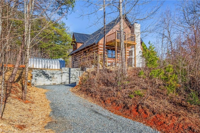 view of side of property featuring metal roof and a chimney