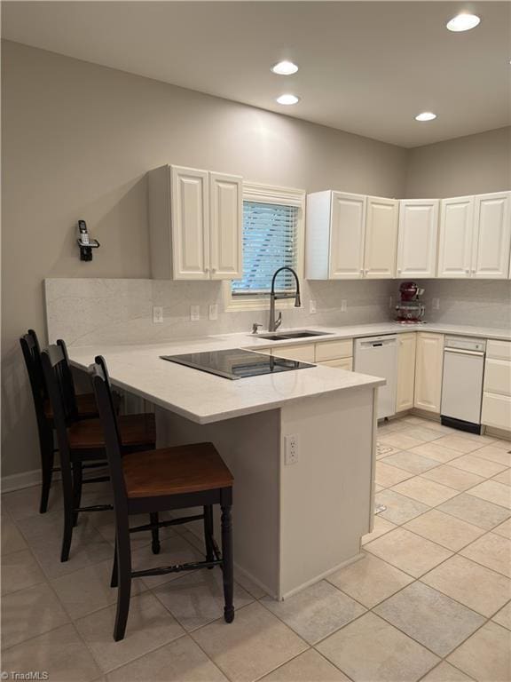 606 Dorado Cir, High Point, NC 27265 - kitchen featuring a sink, a kitchen bar, white dishwasher, a peninsula, and tasteful backsplash